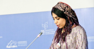 Ghanimat Azhdari, giving speech wearing a tradional dress