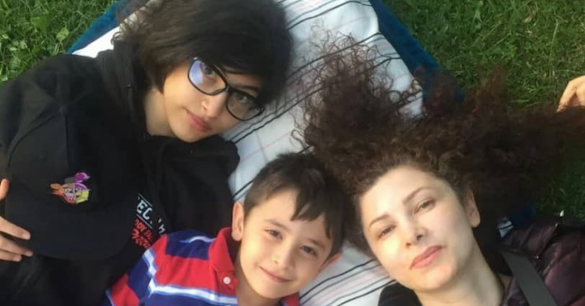 Faezeh Falsafi lying on grass with Dorsa and Daniel Ghandchi